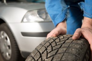 Logel's car mechanic inspecting a car tire.