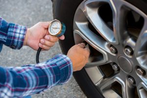 Checking tire pressure with pressure gauge.