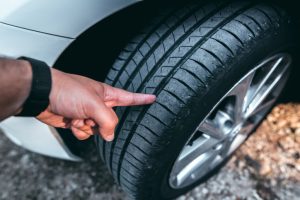 Checking the wear on a tire tread.