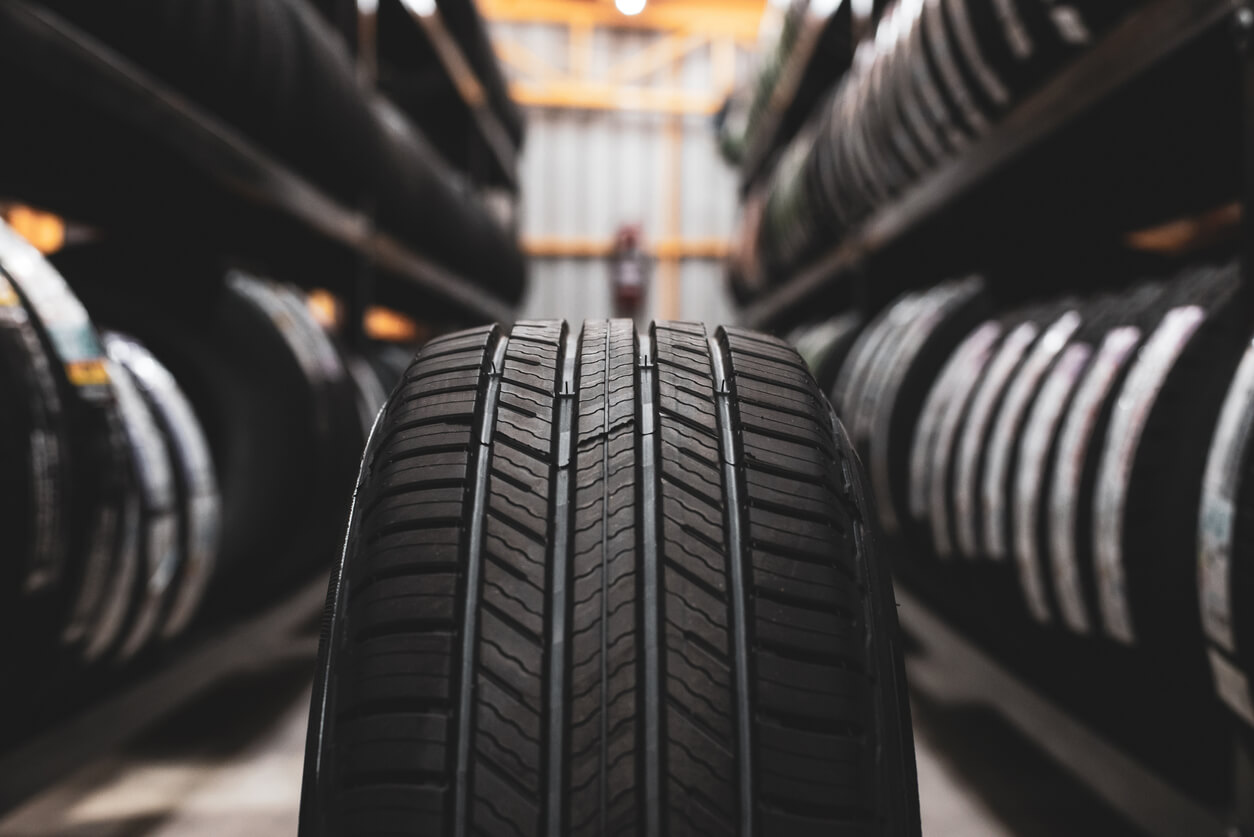 A close up of a tire in the aisle of a row of stored tires
