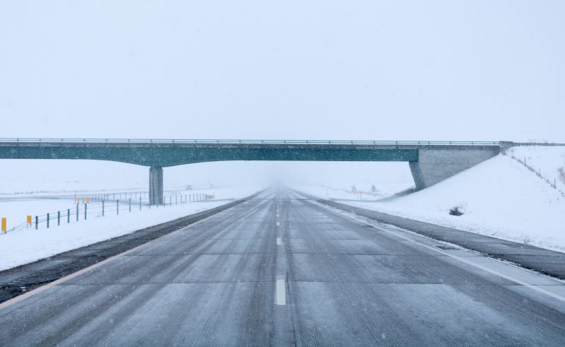 A photo of a highway and overpass in winter.