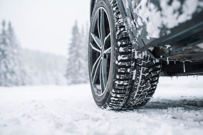 A photo of a car winter tire driving on snow.