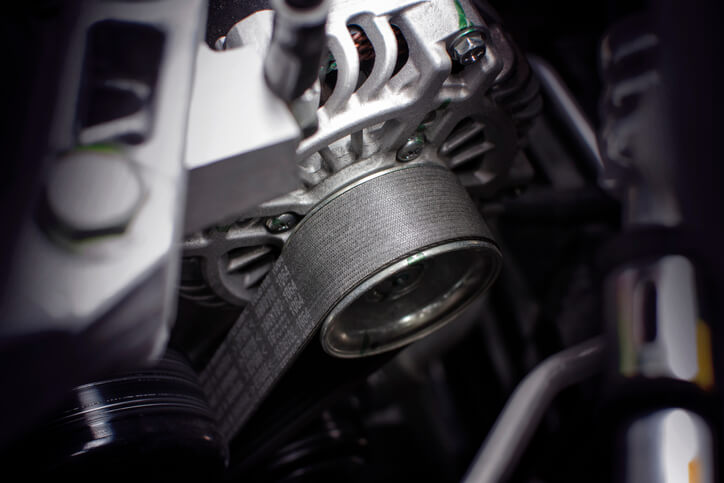 A photo of a timing belt of alternator in a car.