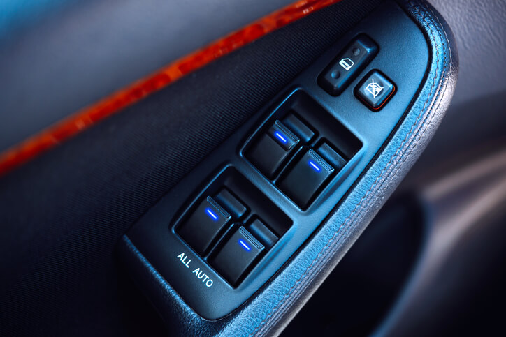 A close up view of buttons for windows control in a car. 