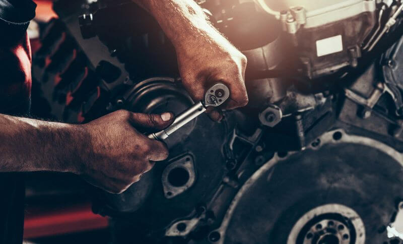 A photo of a mechanic working on a car part.