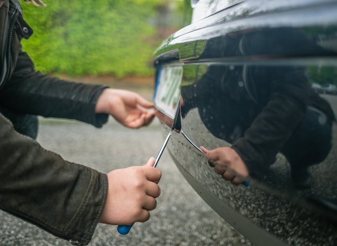 Removing a license plate off a car.