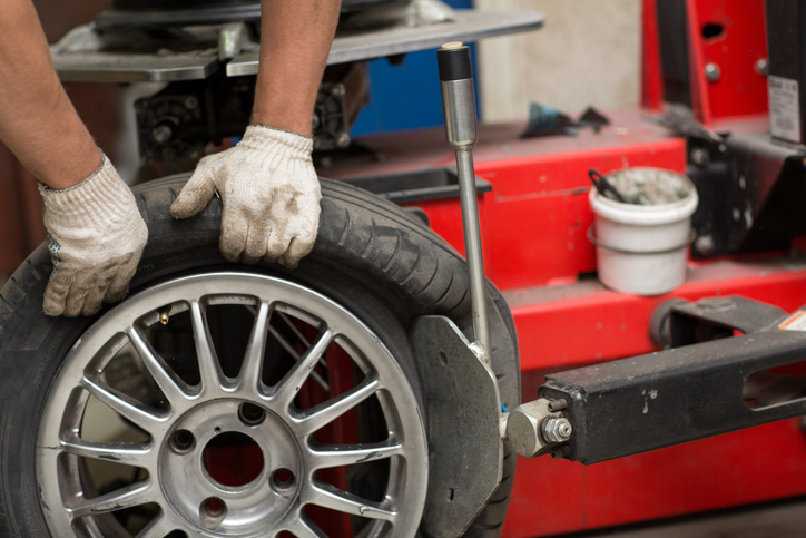 Mechanic changing car tire fitting.