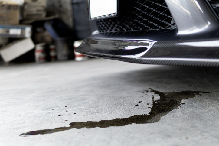 Car engine leaking oil on concrete floor.